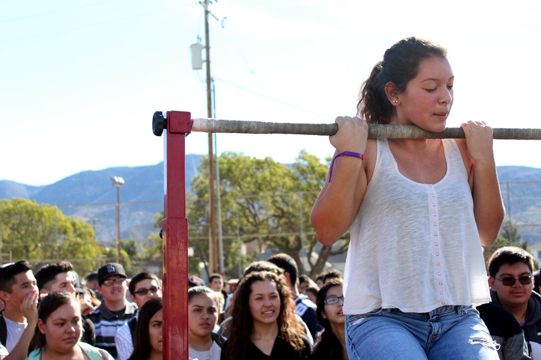 A student of Santa Paula High School conducts the flexed-arm hang during the Marine Corps pull-up challenge at the high school, Dec. 8, 2015, in Santa Paula, Calif., as part of an ASA High School Tour event. ASA brings in five of the world's top professional skateboarders, inline skaters and BMX riders from the X Games to perform on a state-of-the art half-pipe. Marines from Recruiting Sub Station Ventura supported the event to inform students about the Marine Corps. (U.S. Marine Corps photo by Staff Sgt. Alicia R. Leaders/Released)