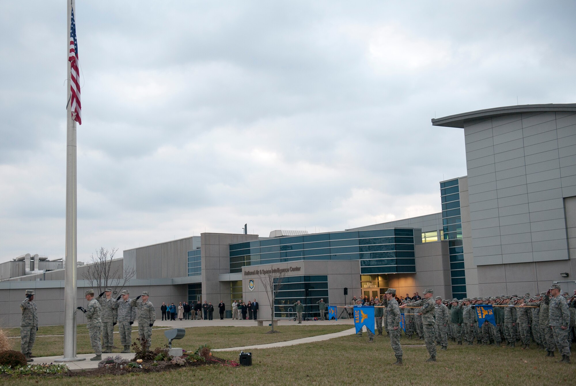 Members of the National Air and Space Intelligence Center salute as the flag is lowered during a retreat ceremony at Wright-Patterson Air Force Base, Ohio, Dec. 7, 2015. The retreat ceremony serves a twofold purpose it signals the end of the official duty day and serves as a ceremony for paying respect to the United States flag.  (U.S. Air Force Photo by Senior Airman Samuel Earick)   