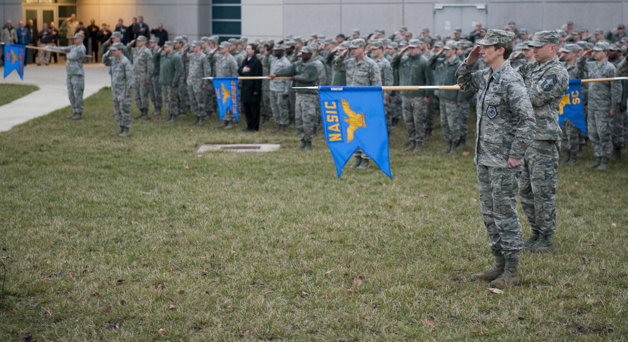Members of the National Air and Space Intelligence Center salute as the flag is lowered during a retreat ceremony at Wright-Patterson Air Force Base, Ohio, Dec. 7, 2015. The retreat ceremony serves a twofold purpose it signals the end of the official duty day and serves as a ceremony for paying respect to the United States flag.  (U.S. Air Force Photo by Senior Airman Samuel Earick)   