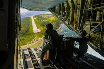 Japanese Air Self-Defense Force Master Sgt. Toyonaga Toshihisa, left, and Tech. Sgt. Takahashi Tetsuki’s, both 1st Tactical Airlift Wing loadmasters,  look over the landing zone on the remote Micronesian island of Asor from the back of a C-130 Hercules Dec. 8, 2015, during Operation Christmas Drop. The 2015 Christmas Drop missions mark the first time the event includes trilateral air support from the JASDF and Royal Australian Air Force. (U.S. Air Force photo/Staff Sgt. Alexander Riedel)
