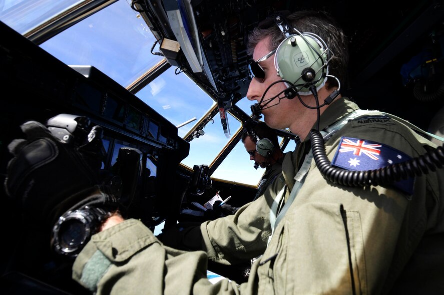 Flying Officer Brendon Carraro, a Royal Australian Air Force C-130J Hercules copilot, takes control of a C-130J Hercules Dec. 8, 2015, during Operation Christmas Drop. This is the first time U.S. allies and international partners from Japan and Australia trained for Humanitarian Aid/Disaster Relief with the U.S. Air Force while providing critical supplies to 56 Micronesian islands impacting approximately 20,000 people covering 1,000 by 1,800 nautical miles of operating area. (U.S. Air Force photo/Staff Sgt. Katrina Brisbin)