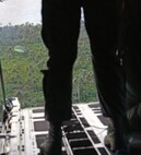 Loadmasters from the 36th Airlift Squadron, Yokota Air Base, watch a low-cost low-altitude bundle filled with donated goods and supplies drop onto the island of Fais from the back of a C-130H during Operation Christmas Drop, Dec. 8, 2015. This is the first trilateral Operation Christmas Drop where the U.S. Air Force, Japan Air Self-Defense Force and the Royal Australian Air Force work together to provide critical supplies to 56 Micronesian islands impacting 20,000 islanders covering 1,000 by 1,800 nautical miles. (U.S. Air Force photo by Tech. Sgt. Melissa K. Mekpongsatorn)