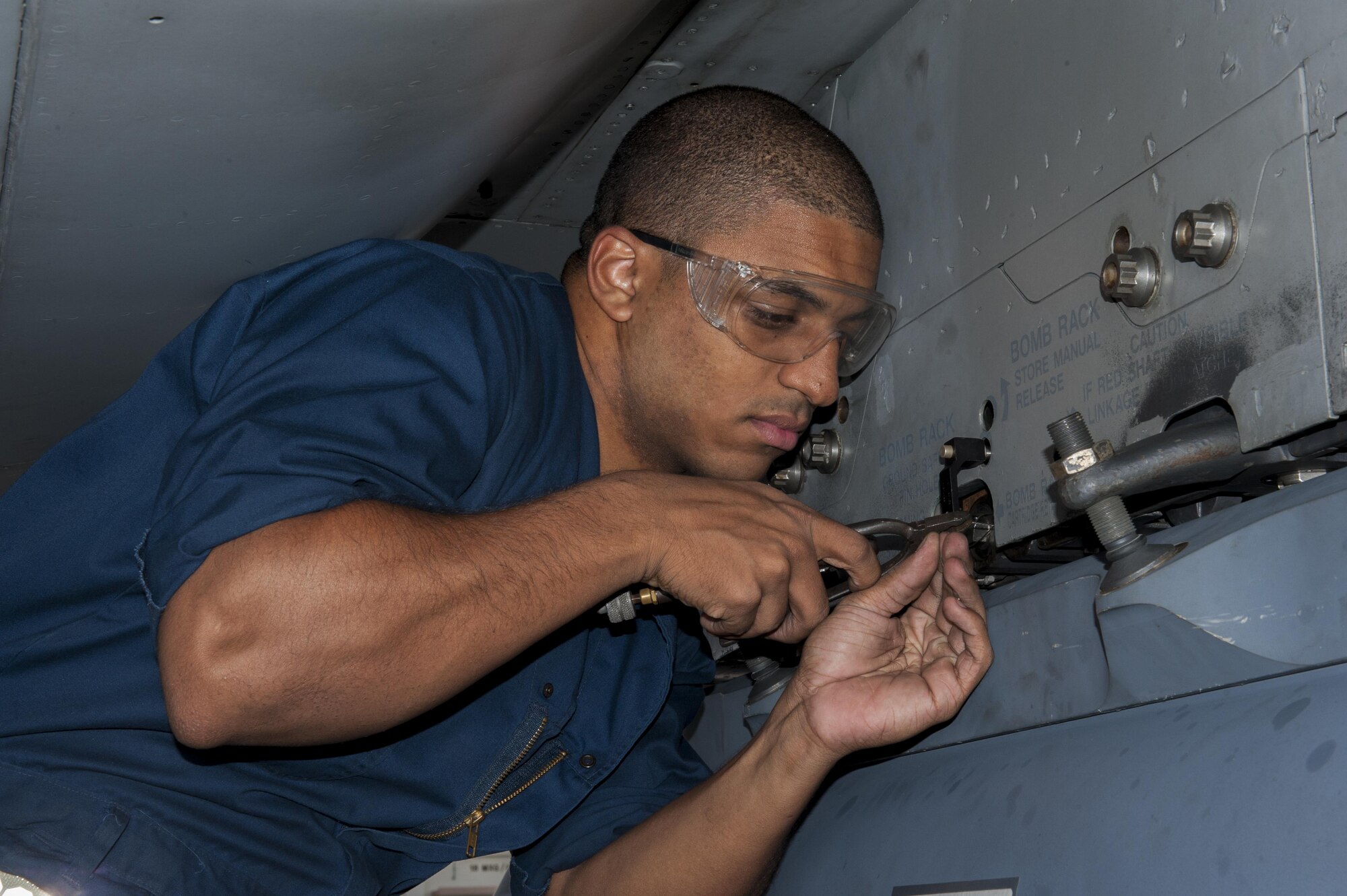 U.S. Air Force Airman 1st Class Brandon Martel, 67th Aircraft Maintenance Unit avionics technician apprentice, secures safety wire for a sniper pod on an F-15C Eagle, Dec. 8, 2015, at Kadena Air Base, Japan. The safety wire and attached pin ensure the sniper pod cannot be accidently jettisoned during flight. (U.S. Air Force photo by Airman Zackary A. Henry)