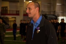 Darren D. Minder, a former Marine Corps sergeant, awaits to be dismissed after receiving the Purple Heart inside the Saginaw Valley State University Field House, Dec. 5, 2015. Darren received the Purple Heart medal for sustaining an enemy gunshot wound to the abdomen while on a patrol during his deployment to Habbinyah, Iraq, as a corporal, Oct. 4, 2006.