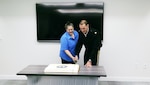Cake-cutting celebrates GuardNet's 15-year hstory. Doing the honors are contractor Mary Proffitt, longest-tenured employee with more 15 years, and Maj. Shannon Huntley, tactical communications branch, Tactical Branch.
