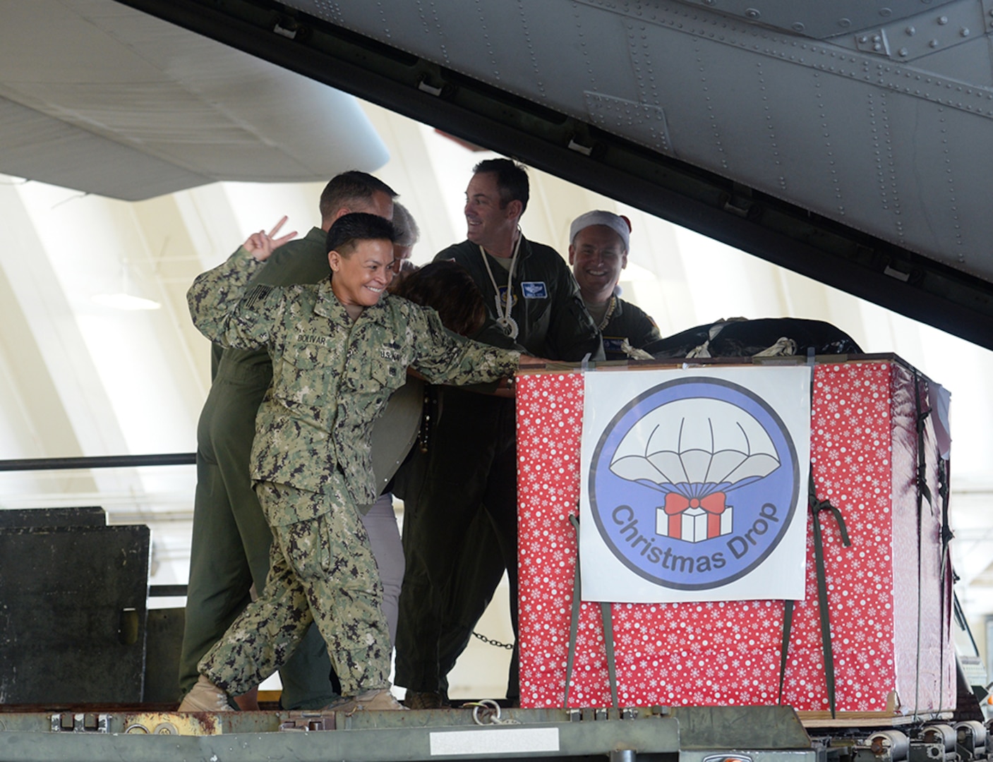 Rear Adm. Babette Bolivar, Joint Region Marianas commander, counts down before pushing a crate containing donated goods into a C-130 Hercules during the Christmas Drop Push Ceremony Dec. 8, 2015, at Andersen Air Force Base, Guam. Operation Christmas Drop, which has been conducted for 64 years, will receive support from the Japanese Air Self Defense Force and the Royal Australian Air Force for the first time. 