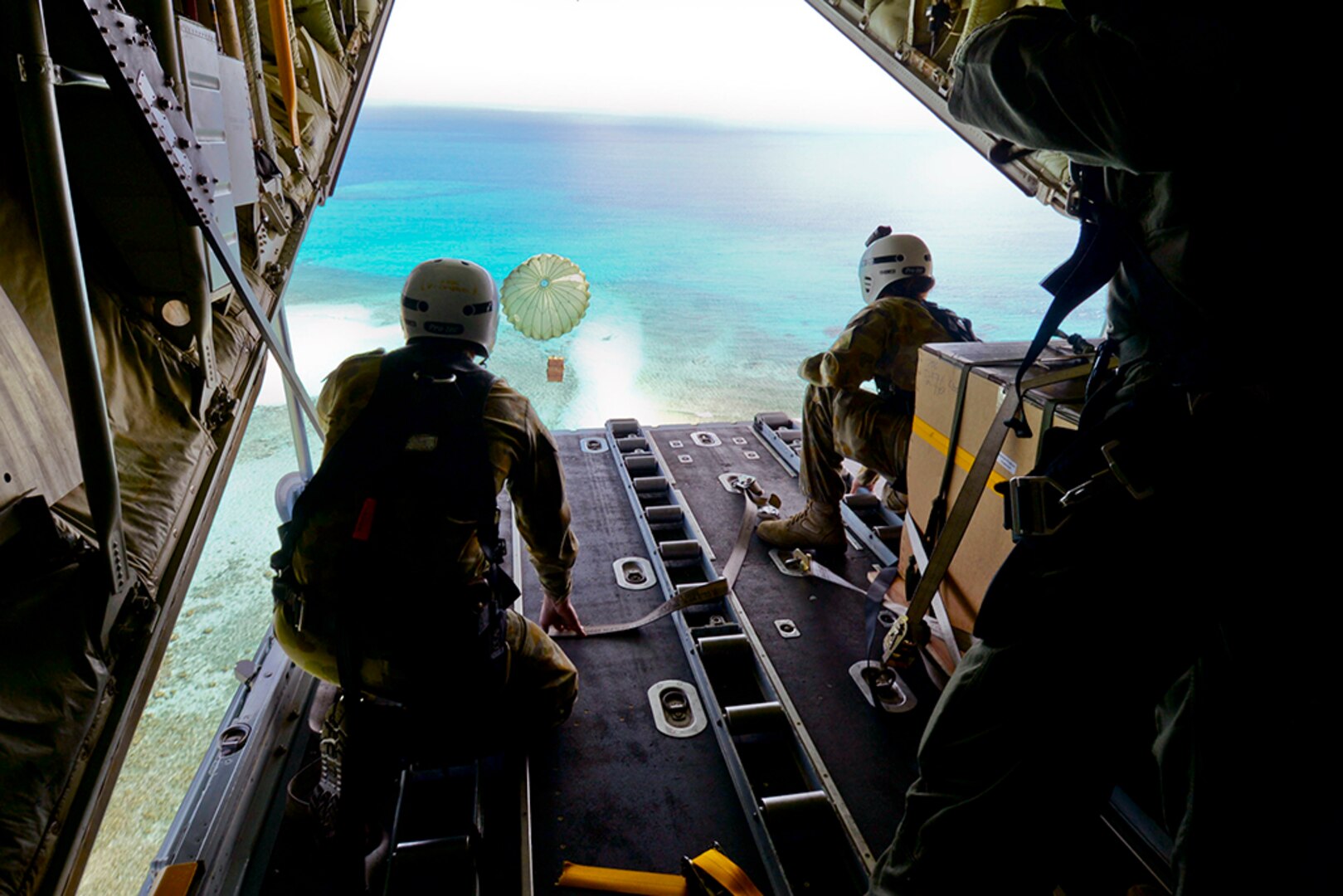 Cpl. Teome Matamua and Sgt. Phillip McIllvaney, Australian Army 176th Air Dispatch Squadron loadmasters, deliver the first low-cost, low-altitude bundle of Operation Christmas Drop 2015 to the island of MogMog, Dec. 8, 2015. Australian and Japanese C-130 aircrews for the first time joined U.S. Airmen during the 64th year of Operation Christmas Drop – a Humanitarian Aid/Disaster Relief training event where C-130 aircrews perform LCLA airdrops on unsurveyed drop zones while providing critical supplies to 56 islands throughout the Commonwealth of the Northern Marianas, Federated States of Micronesia and Republic of Palau. It highlights the U.S. and allied airpower capabilities to orient and respond to activities in peacetime and crisis. 