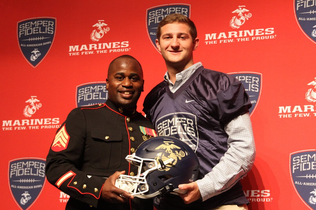 Sgt. Allen Leonard Jr., canvassing recruiter, Marine Corps Recruiting Station Columbia and Austin Kendall, quarterback, Cuthbertson High School pose for a photo after the Semper Fidelis All-American Bowl jersey presentation at Cuthbertson High School on Nov.3, 2015. Kendall was presented with his jersey in front of his football team, coaching staff, friends and family.
