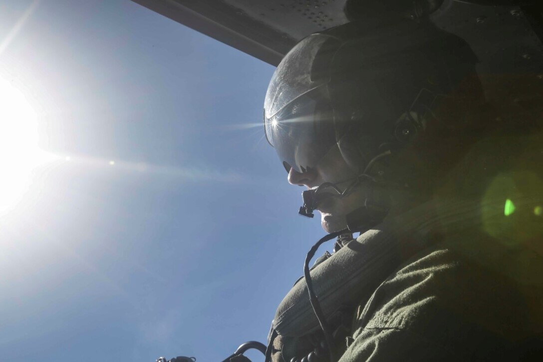 PACIFIC OCEAN  (Nov. 30, 2015) U.S. Marine Cpl. Cody L. Daniel relays flight information to the pilots aboard a UH-1Y Venom. Daniel is a crew chief with Marine Medium Tiltrotor Squadron 161, 15th Marine Expeditionary Unit. The 15th MEU is currently deployed in the Indo-Asia-Pacific region to promote regional stability and security in the U.S. 7th Fleet area of operations. (U.S. Marine Corps photo by Sgt. Jamean Berry/Released)