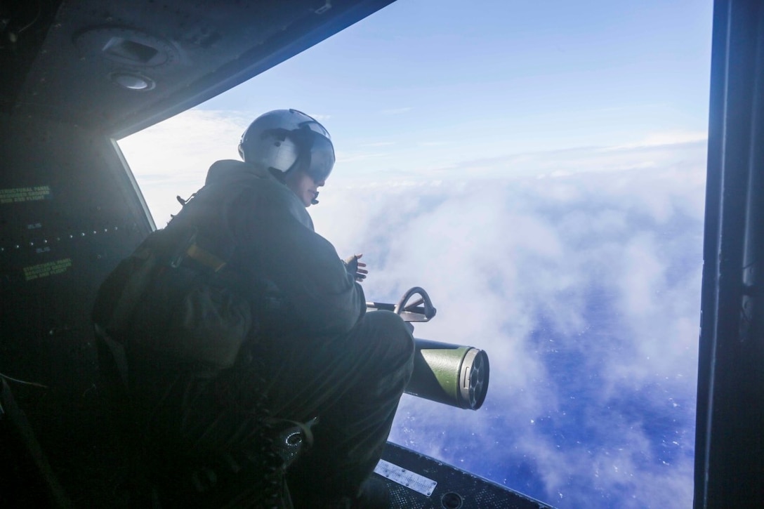 PACIFIC OCEAN (Nov. 30, 2015) U.S. Marine Cpl. Daniel A. Alfaro looks out the door of a UH-1Y Venom over the Pacific Ocean. Alfaro is a crew chief with Marine Medium Tiltrotor Squadron 161, 15th Marine Expeditionary Unit. The 15th MEU is currently deployed in the Indo-Asia-Pacific region to promote regional stability and security in the U.S. 7th Fleet area of operations. (U.S. Marine Corps photo by Sgt. Jamean Berry/Released)