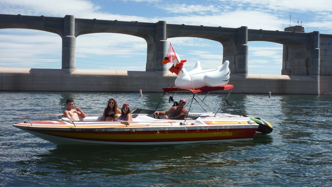 CONCHAS LAKE, N.M. – Lake visitors in their boat with their mascot Sasha the swan, Sept. 6, 2015. Sasha has her ski flag and life jacket on.  Sasha has been visiting the lake all summer. Photo by Valerie Mavis. This was a 2015 photo drive entry.