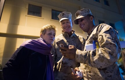 A U.S. Marine shows a photo to U.S. Marine Corps Gen. Joseph F. Dunford Jr., chairman of the Joint Chiefs of Staff, and his wife, Ellyn Dunford, at Naval Support Activity Bahrain, Dec. 7, 2015. DoD photo by D. Myles Cullen