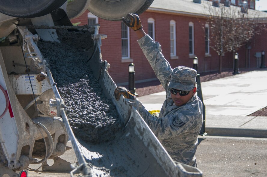 Staff Sgt. David Vaughner, 90th Civil Engineer Squadron Heavy Equipment, guides the concrete pouring outside along the road outside the Chadwell Dining Facility on F.E. Warren Air Force Base, Wyo., Nov. 10, 2015. CE Airmen perform maintenance on roads, interior lighting, heating, ventilation, air conditioning and other projects on base. (U.S. Air Force photo by Senior Airman Jason Wiese)