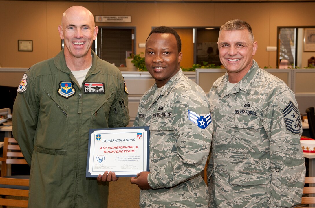 Airman 1st Class Christophore Hountohotegbe, a 71st Force Support Squadron force management journeyman, accepts his senior airman below the zone stripes from Col. Clark Quinn, the 71st Flying Training Wing commander, and Chief Master Sgt. Peter Speen, the 71st FTW command chief, Dec. 7. BTZ allows commanders to promote a select number of outstanding airmen 1st class to senior airmen six months early. Airman “H” as his peers call him is set to sew on E-4 Feb. 8, 2016. (U.S. Air Force photo by Tech. Sgt. James Bolinger)