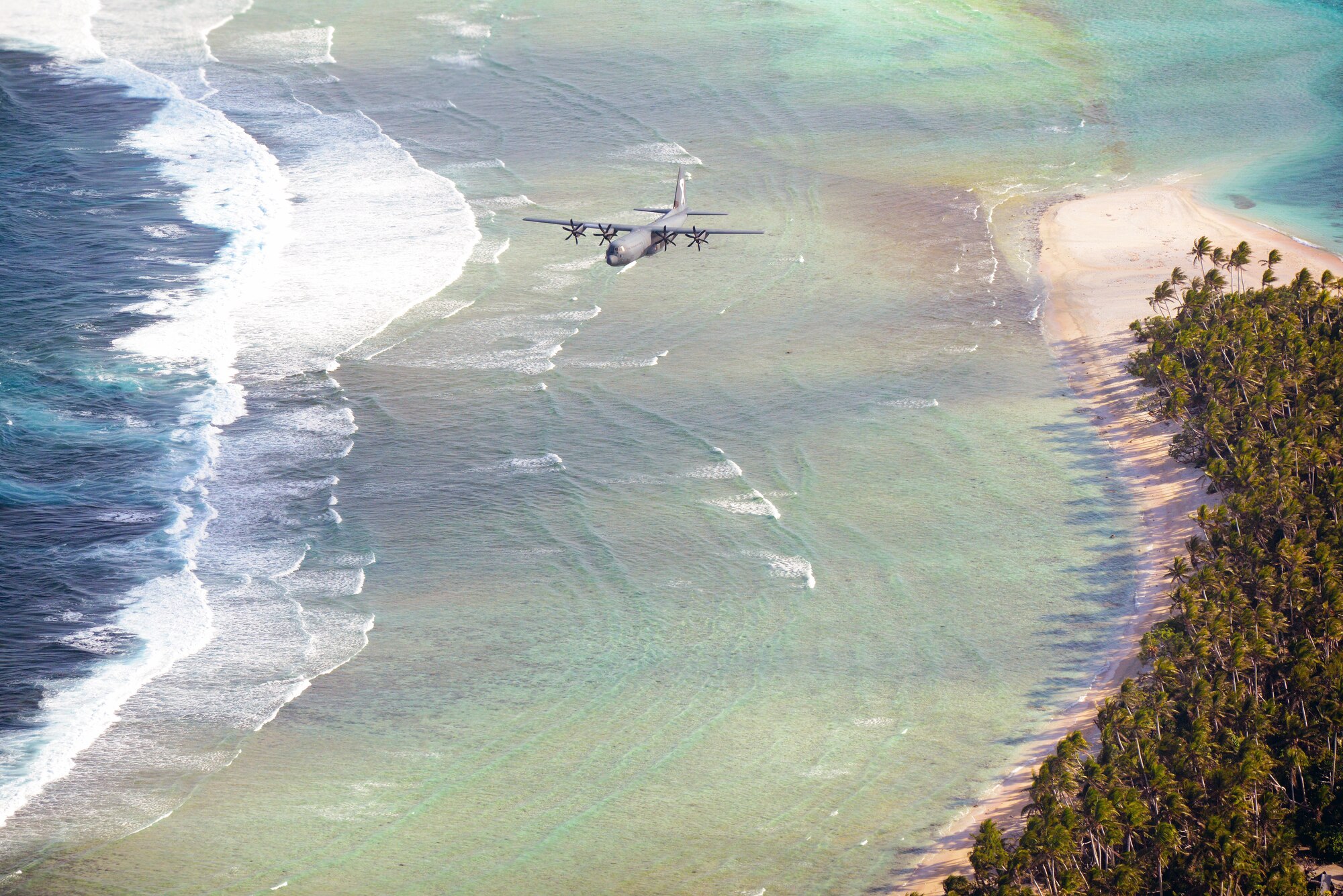 A Royal Australian Air Force C-130J flies over the Federated States of Micronesia during Operation Christmas Drop, Dec. 8, 2015. The RAAF dropped the first official bundle to the island of MogMog during the first trilateral execution of the training mission alongside Japanese Air Self-Defense Force and U.S. Air Force. Operation Christmas Drop is a humanitarian aid/disaster relief training event where C-130 crews provide critical supplies to 56 islands throughout the Commonwealth of the Northern Marianas, Federated States of Micronesia and Republic of Palau. (U.S. Air Force photo by Tech. Sgt. Melissa K. Mekpongsatorn)