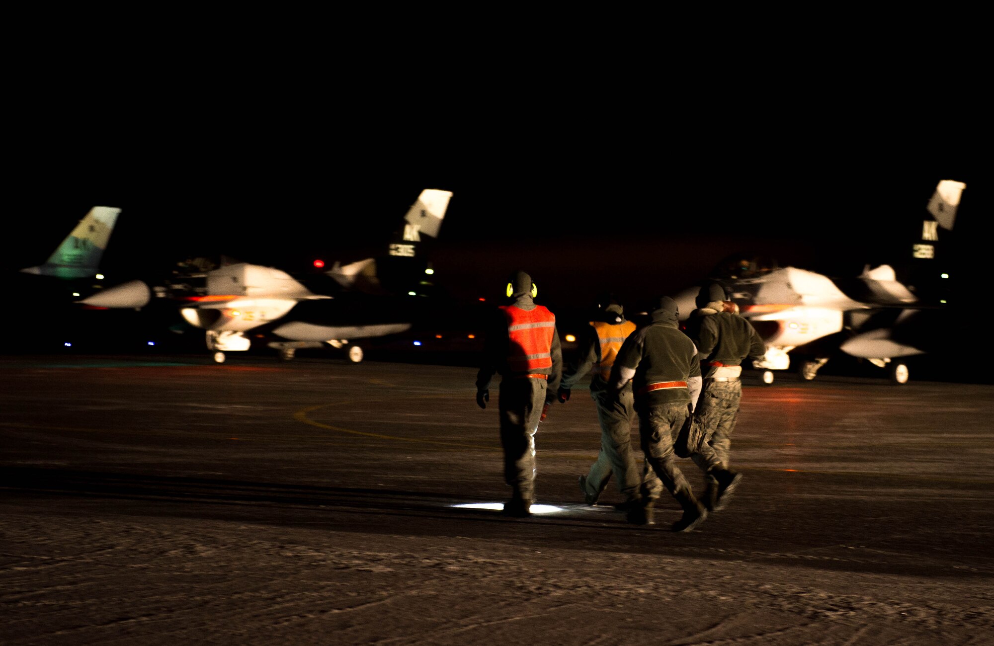 Airmen from the 354th Aircraft Maintenance Squadron rush to perform the last pre-flight checks on an F-16 Fighting Falcon fighter aircraft Dec. 7, 2015, at Eielson Air Force Base, Alaska. More than 30 maintenance Airmen worked an early shift to help launch several jets to Tyndall Air Force Base, Florida, for CHECKERED FLAG 16-1, a large-force exercise that simulates a large number of aircraft in a deployed environment to cross-check weapons systems. (U.S. Air Force photo by Staff Sgt. Shawn Nickel/Released)