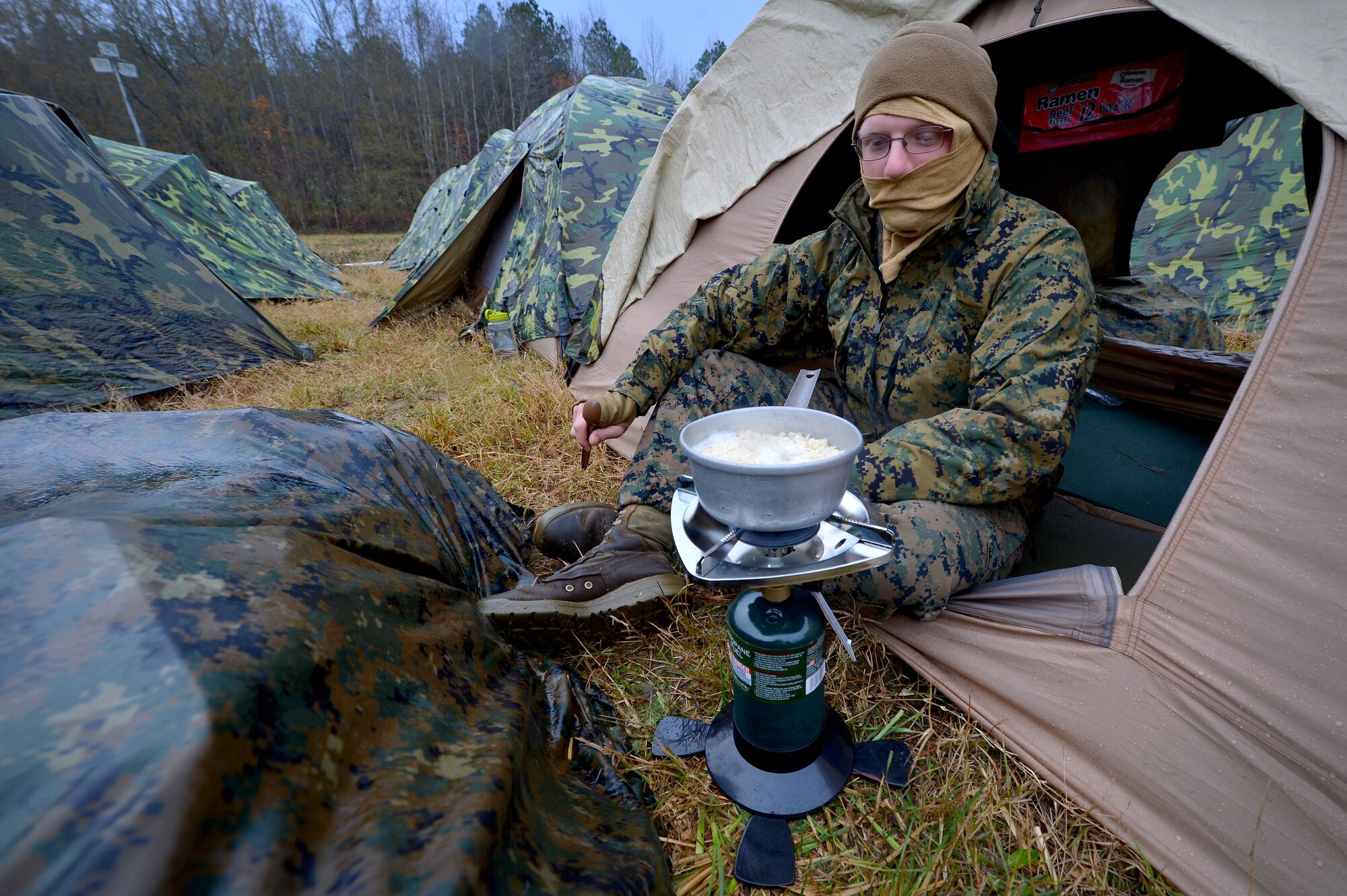 A U.S. Marine assigned to the 273rd Marine Wing Support Squadron heats up a bowl of noodles at Poinsett Electronic Combat Range, Wedgefield, S.C., Dec. 7, 2015. The Marines came to Poinsett to set up for a week long exercise that will test their combat and teamwork capabilities. (U.S. Air Force photo by Senior Airman Michael Cossaboom)