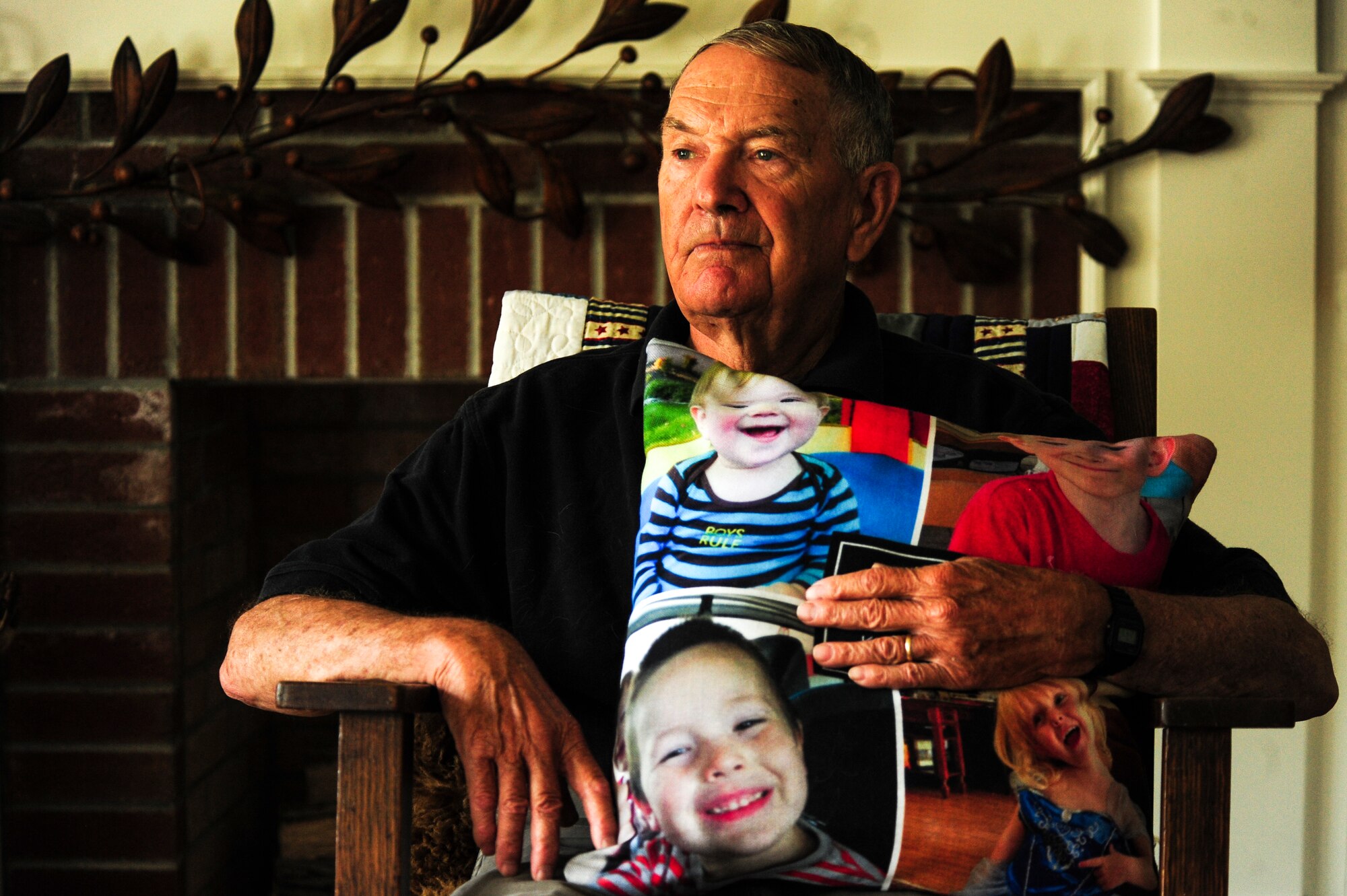 Retired U.S. Army Col. Walter “Joe” Marm holds a pillow with pictures of his grandchildren as he relaxes in his family room, June 30, 2015, at his home in Fremont, North Carolina. Marm commissioned in the Army in 1965 and served as a platoon leader in the 1st Cavalry Division in the Vietnam War. (U.S. Air Force photo/Senior Airman Brittain Crolley)