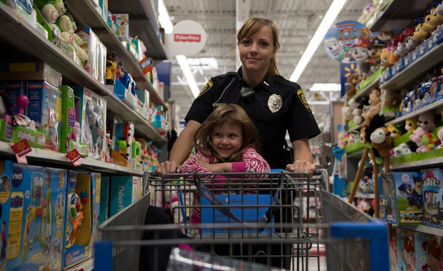 A local officer from the community and a Shop with a Cop participant browse the toy aisles during a shopping trip in Mountain Home, Idaho, Dec. 5, 2015. Roughly 75 law enforcement and first responders volunteered to partake the in Shop with a Cop event. (U.S. Air Force photo by Airman 1st Class Connor J. Marth/Released)