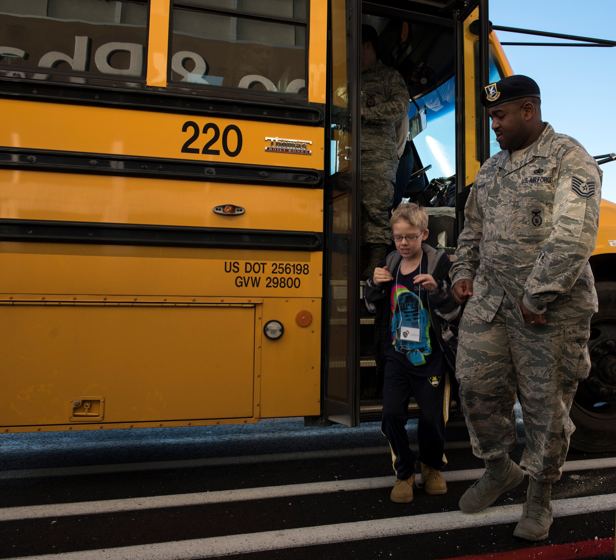 Tech. Sgt. Kenneth Graham, 366th Security Forces NCO in charge of standardization evaluation, departs the bus at the final destination of the day for the Shop with a Cop event, Dec. 5, 2015, Mountain Home, Idaho. Members from Mountain Home Air Force Base volunteered to give back to the youth of the community by hanging out with them and taking them shopping. (U.S. Air Force photo by Airman 1st Class Connor J. Marth/Released)