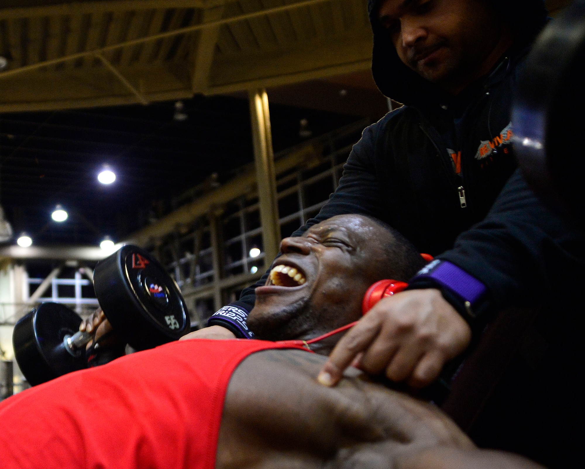 Tech. Sgt. David, 432nd Maintenance Group contract officer representative, performs chest flyes  while his trainer, Derrick Chandler, motivates him during a workout Dec. 4, 2015, at Nellis Air Force Base, Nevada. David recently attained his International Federation of Bodybuilding and Fitness professional card which allows him to compete in professional bodybuilding competitions. (U.S. Air Force photo by Airman 1st Class Christian Clausen/Released)