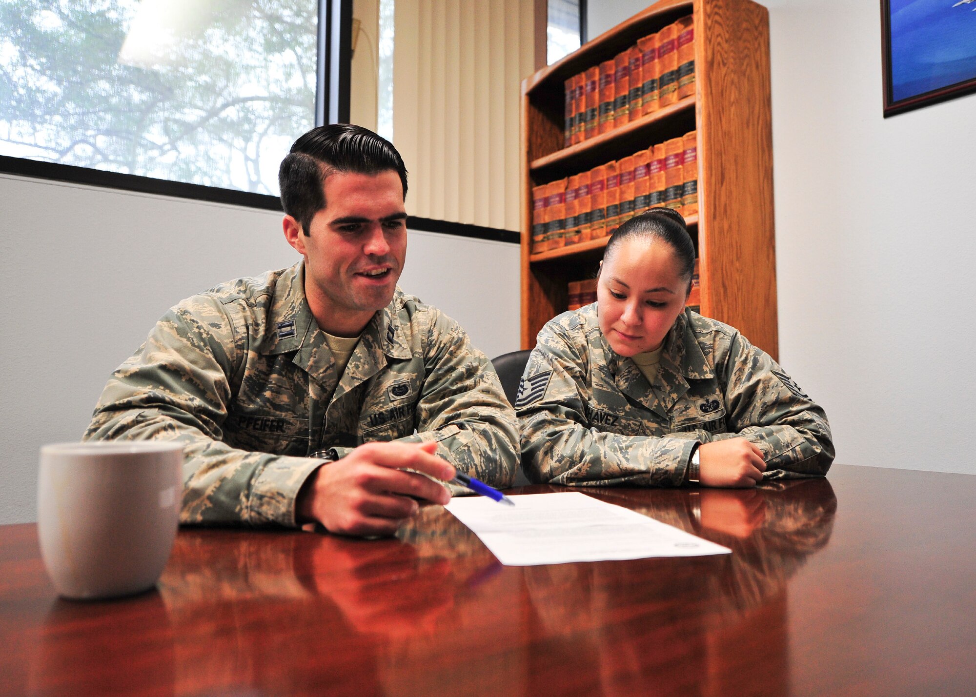 Captain Tom Pfeifer, 325th Fighter Wing Legal Office chief of civil law, and Tech. Sgt. Audri Chavez, 325th FW Legal Office NCO in-charge of general and civil law, review a legal document Dec. 3 in the Tyndall legal office. The legal office provides advice to the wing commander, and ensures policies and decisions are lawful. The legal office also provides other decision-makers at all levels with advice and recommendations needed to best evaluate options and properly resolve complex issues.