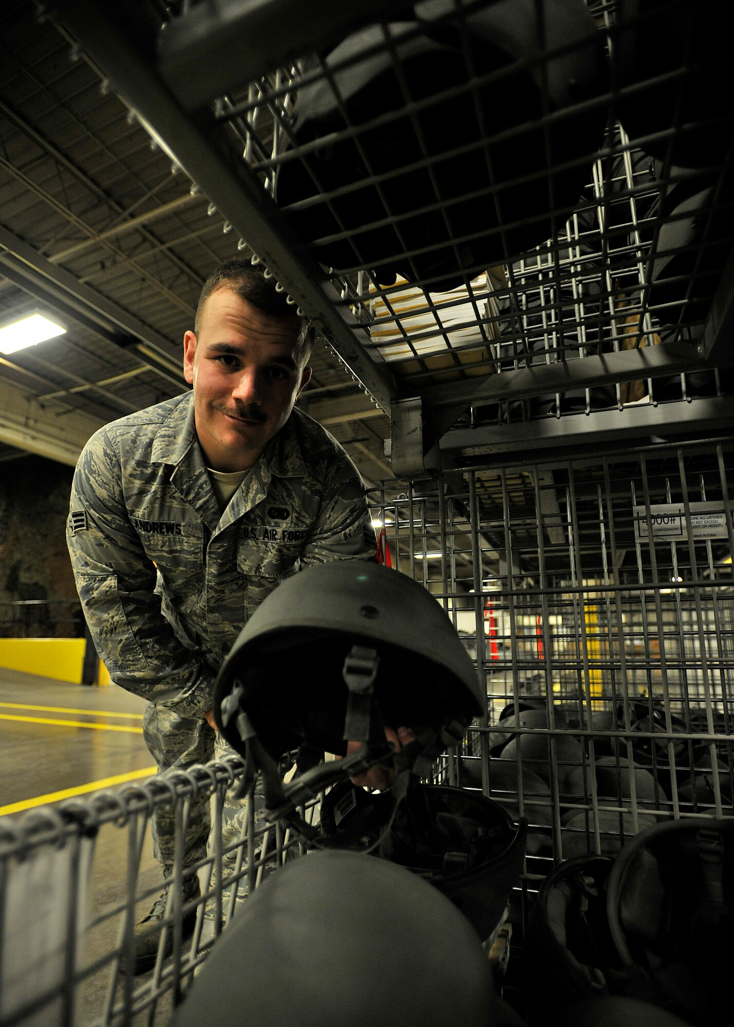 Senior Airman Joshua Andrew, 319th Logistics Readiness Squadron individual protective equipment journeyman, examines a helmet before packing it into a deployment bag on Grand Forks Air Force Base, North Dakota, Dec. 8, 2015. The Hill City, Minnesota, native was named Warrior of the Week for the second week in December 2015. (U.S. Air Force photo by Senior Airman Xavier Navarro/Released)