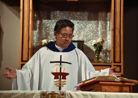 Father Juan Salonga, 92nd Air Refueling GS Catholic Priest, reads from the Sacramentary during Catholic Mass Dec. 8, 2015, in the base chapel at Fairchild Air Force Base, Wash. Before becoming a chaplain, Father Juan served 14 years in the United States Navy. “When I joined the Navy, I never thought I would function as a catechist or activist in the church,” said Father Juan. “But I was wrong.” All throughout his navy career, Father Juan volunteered in the church and soon realized it was his dream to become a military chaplain. (U.S. Air Force Photo/Airman 1st Class Taylor Bourgeous)