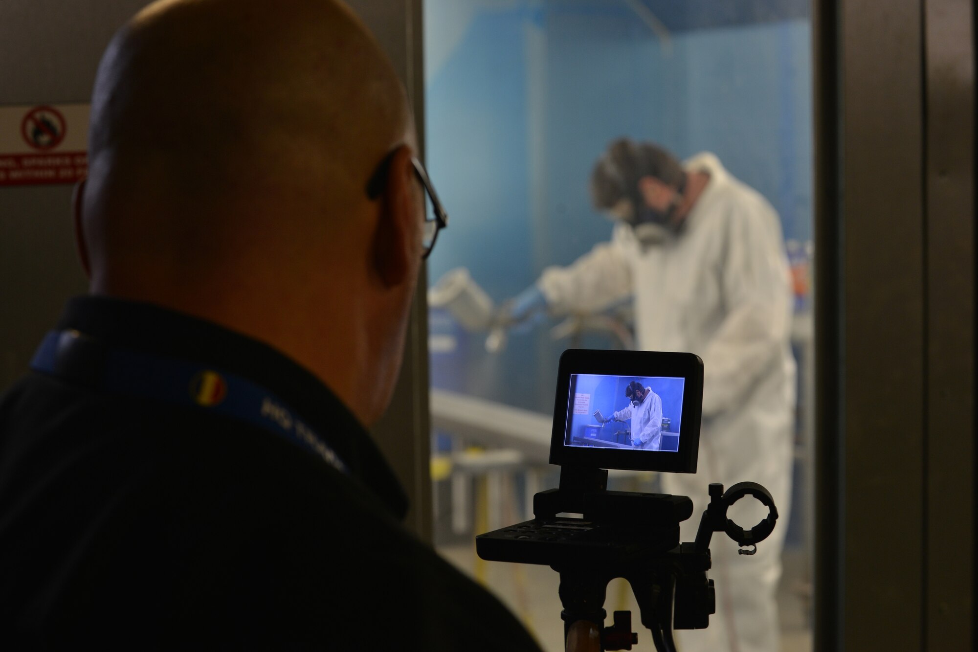 Joint Base Langley-Eustis Enterprise Multimedia Center (EMC), audiovisual technicians film Keith Collier, an audiovisual specialist with EMC, as he paints a flag stand at Fort Eustis, Va., Dec. 1, 2015. The EMC staff covers a range of capabilities including audiovisual support, graphics, television and video production, fabrication, photography and large format print.  (U.S. Air Force photo by Staff Sgt. Natasha Stannard)