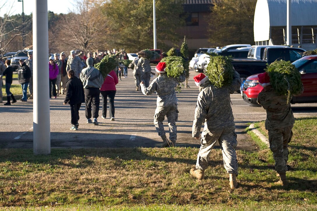 U.S. Soldiers carry Christmas trees to their vehicles during the Trees for Troops event at Fort Eustis, Va., Dec. 4, 2015. Over 40 volunteers unloaded and loaded 400 trees, which were donated by a tree farm in Massachusetts for the event. (U.S. Air Force photo by Senior Airman Breonna Veal)