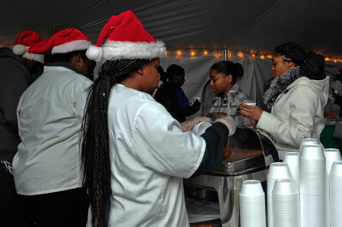 Volunteers serve chili and hot dogs to patrons of the Holiday Tree Lighting Ceremony at Seay Plaza at Fort Eustis, Va., Dec. 4, 2015. The ceremony also featured holiday songs played by the U.S. Army Training and Doctrine Command band. (U.S. Air Force photo by Senior Airman Breonna Veal)