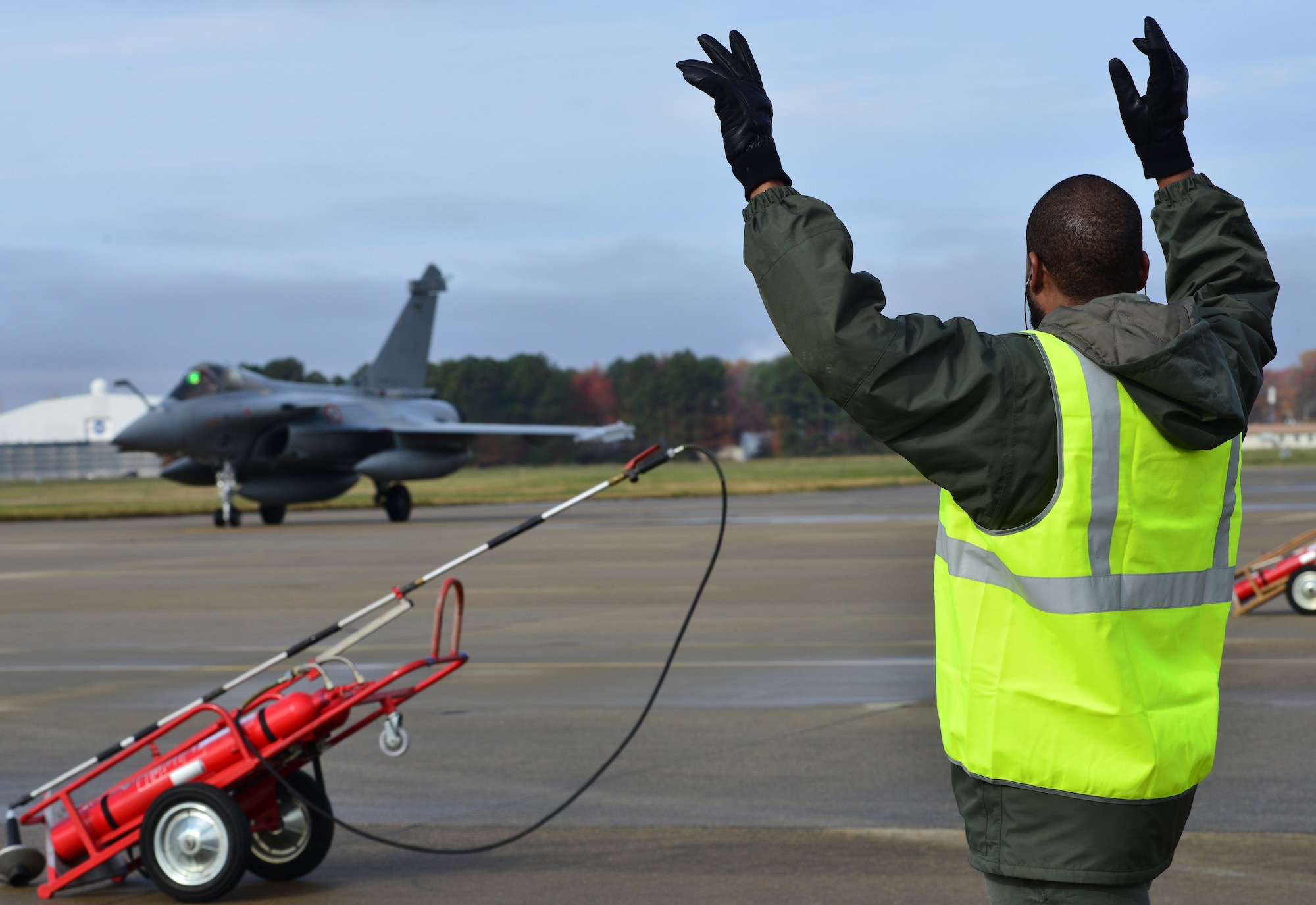 A French air force crew chief directs a Rafale to its parking spot prior to the inaugural Trilateral Exercise, at Langley Air Force Base, Va., Dec. 1, 2015. According to the Rafale’s maker, Dassault Aviation, the combat-proven aircraft is of a moderate size, yet powerful, agile and discrete. (U.S. Air Force photo by Senior Airman Aubrey White)