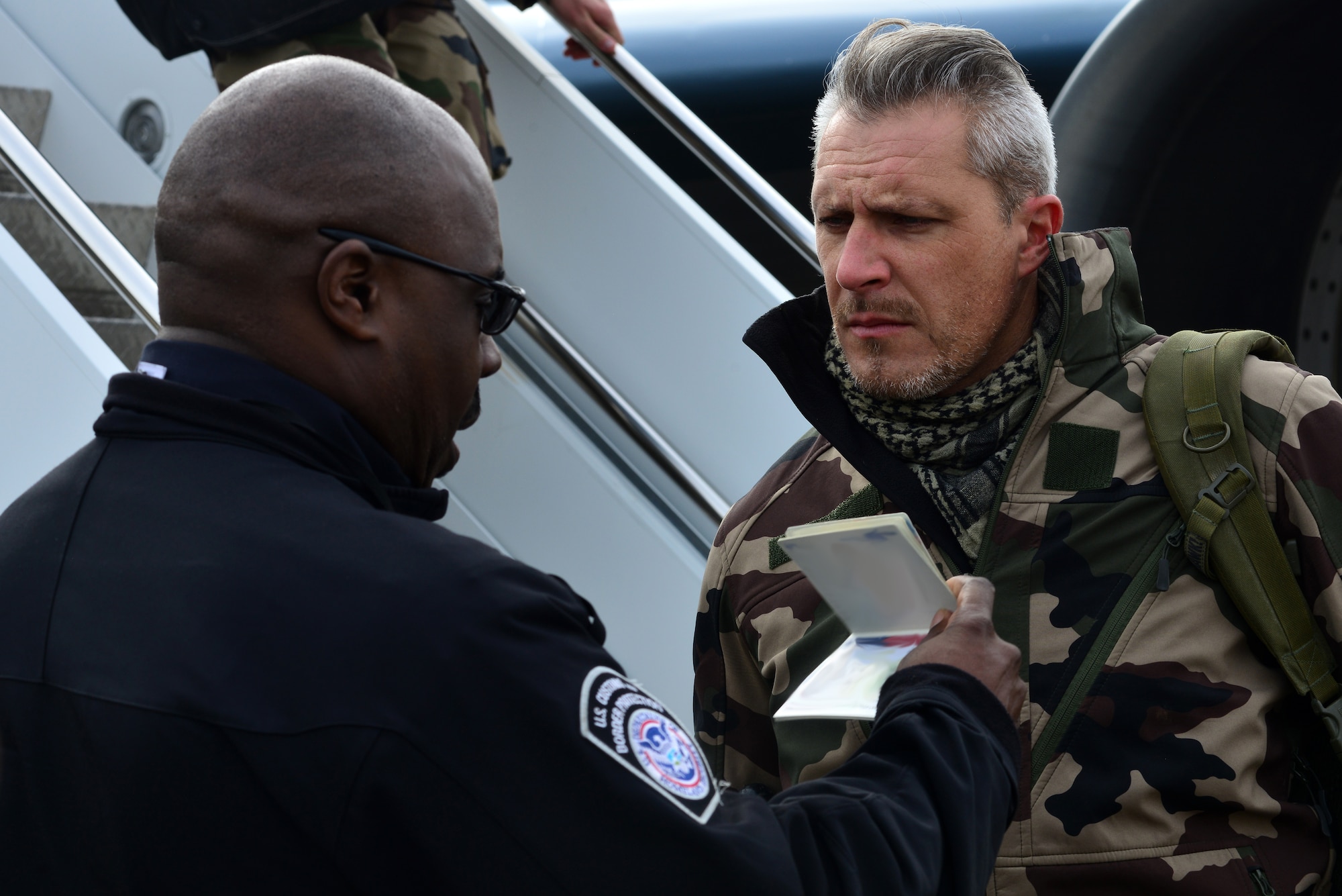 A U.S. Customs and Border Protection agent verifies the identification of a member of the French air force (FrAF) prior to the inaugural Trilateral Exercise, at Langley Air Force Base, Va., Dec. 1, 2015. Approximately 325 British Royal Air Force and FrAF personnel traveled to the U.S. to participate in the exercise. (U.S. Air Force photo by Senior Airman Aubrey White)
