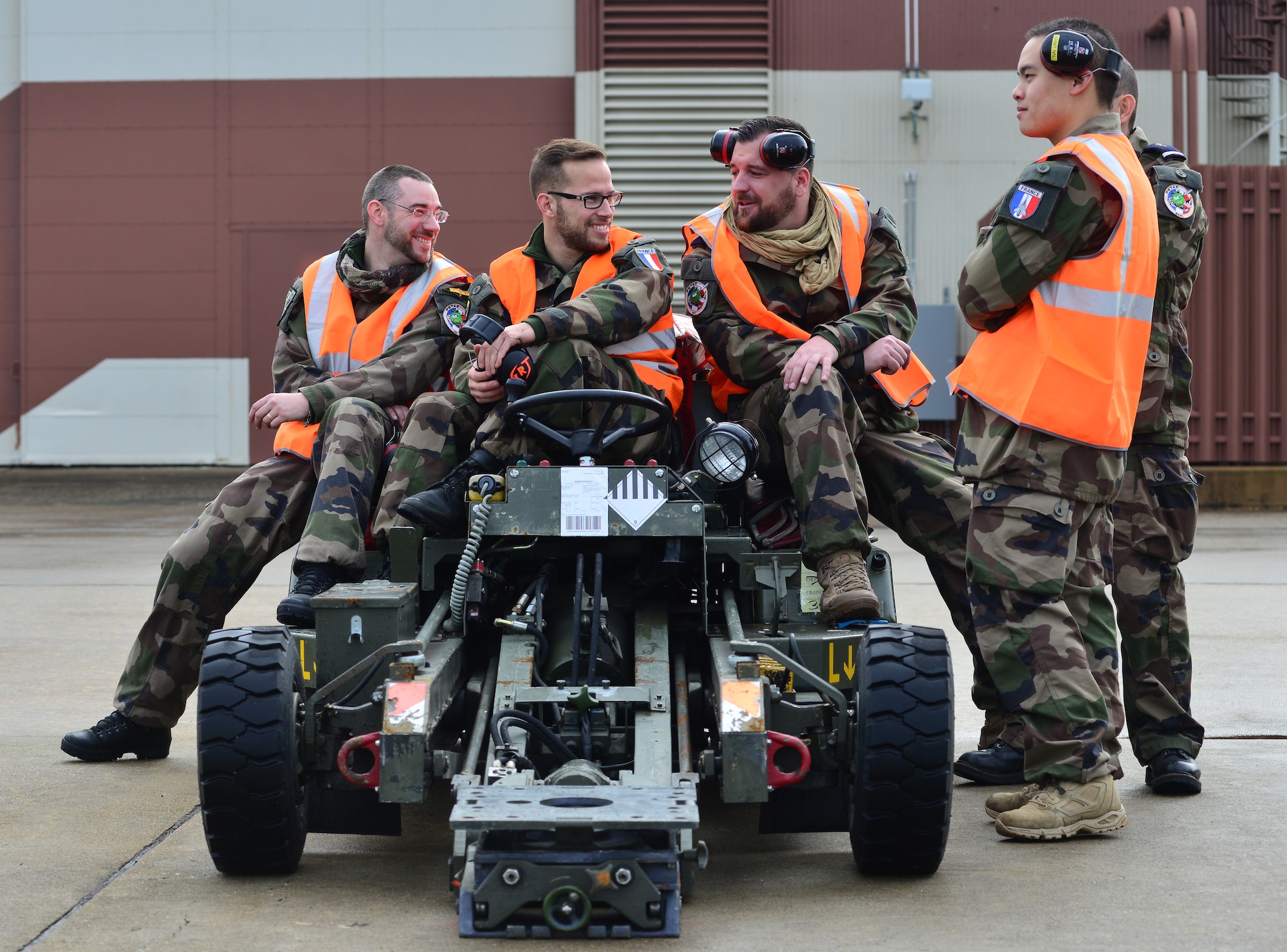 Members of the French air force gather around a munitions jammer to await the arrival of French aircraft prior to the inaugural Trilateral Exercise, at Langley Air Force Base, Va., Dec. 1, 2015. The exercise provides an opportunity for U.S. Airmen and international partners to experience realistic combat scenarios that enhance their ability to fight together in contemporary anti-access/area denial environments. (U.S. Air Force photo by Senior Airman Aubrey White)