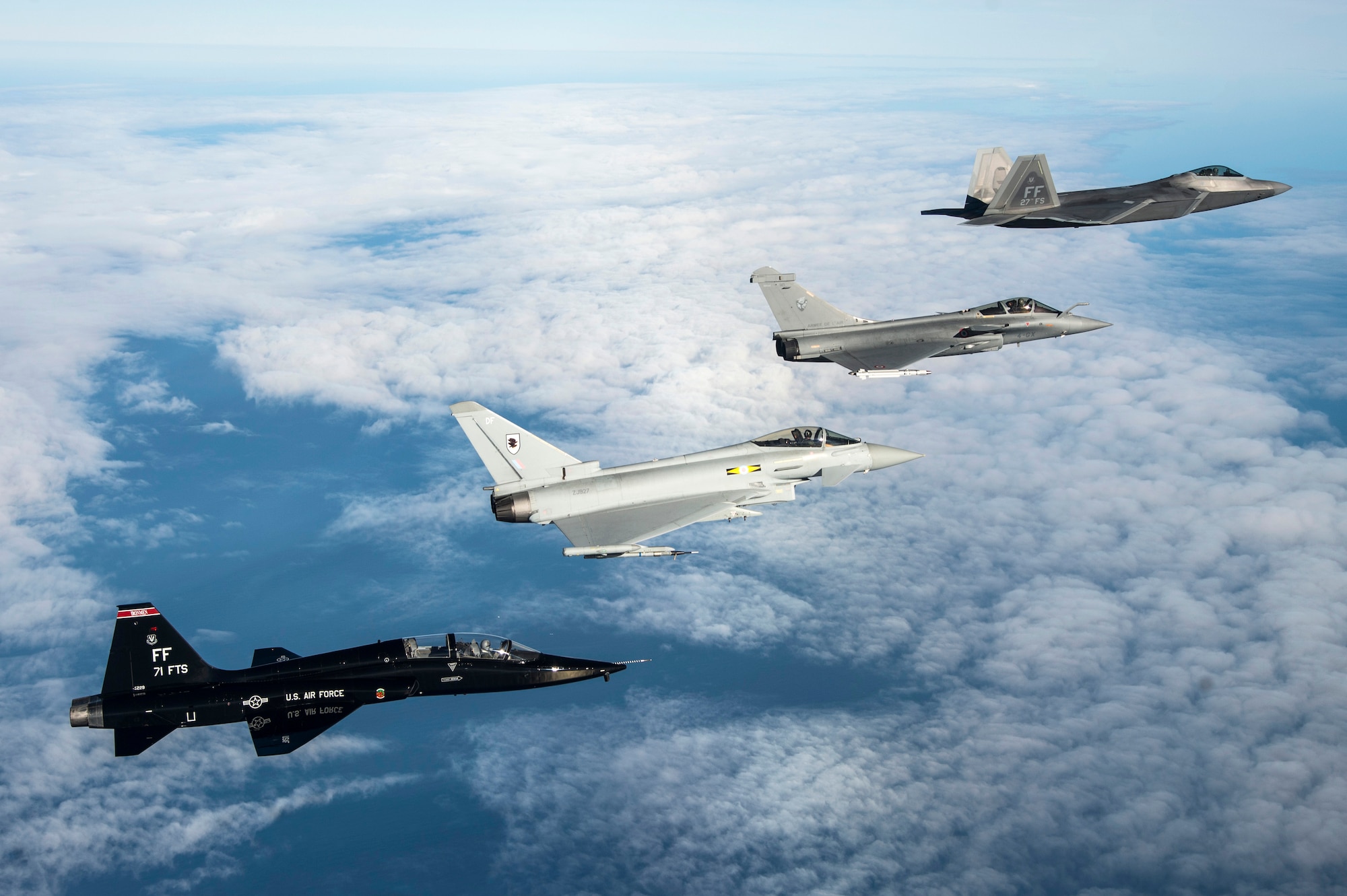 A U.S. Air Force T-38 Talon, British Royal Air Force Typhoon, French air force Rafale and U.S. Air Force F-22 Raptor fly in formation as part of a Trilateral Exercise held at Langley Air Force Base, Va., Dec. 7, 2015. The 1st Fighter Wing hosted the exercise which focuses on operations in a highly-contested operational environment. (U.S. Air Force photo by Senior Airman Kayla Newman)