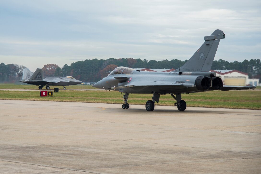 A French air force Rafale and U.S Air Force F-22 Raptor prepare to takeoff at Langley Air Force Base, Va., Dec. 7, 2015. The U.S., RAF and French air force are conducting a Trilateral Exercise to share and develop training, tactics and procedures, enabling interoperability among allies. (U.S. Air Force photo by Senior Airman Kayla Newman)