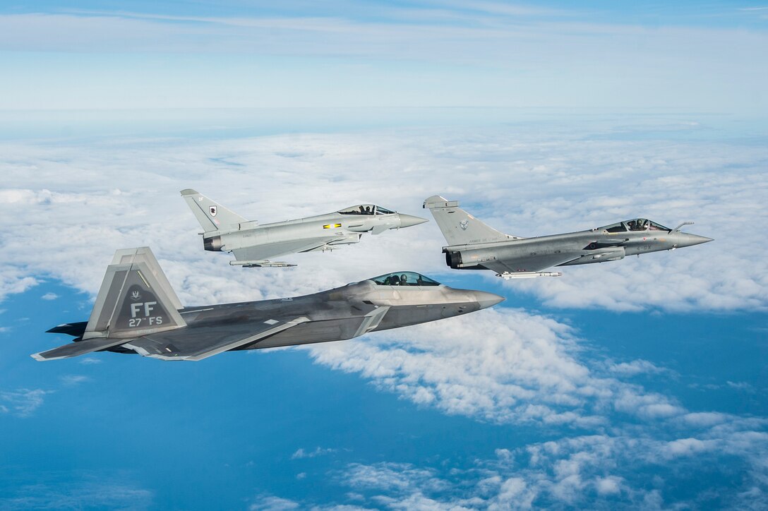 A U.S. Air Force F-22 Raptor, British Royal Air Force Typhoon, and French air force Rafale fly in formation as part of a Trilateral Exercise held at Langley Air Force Base, Va., Dec. 7, 2015. The exercise simulates a highly-contested, degraded and operationally-limited environment where U.S. and partner pilots and ground crews can test their readiness. (U.S. Air Force photo by Senior Airman Kayla Newman)