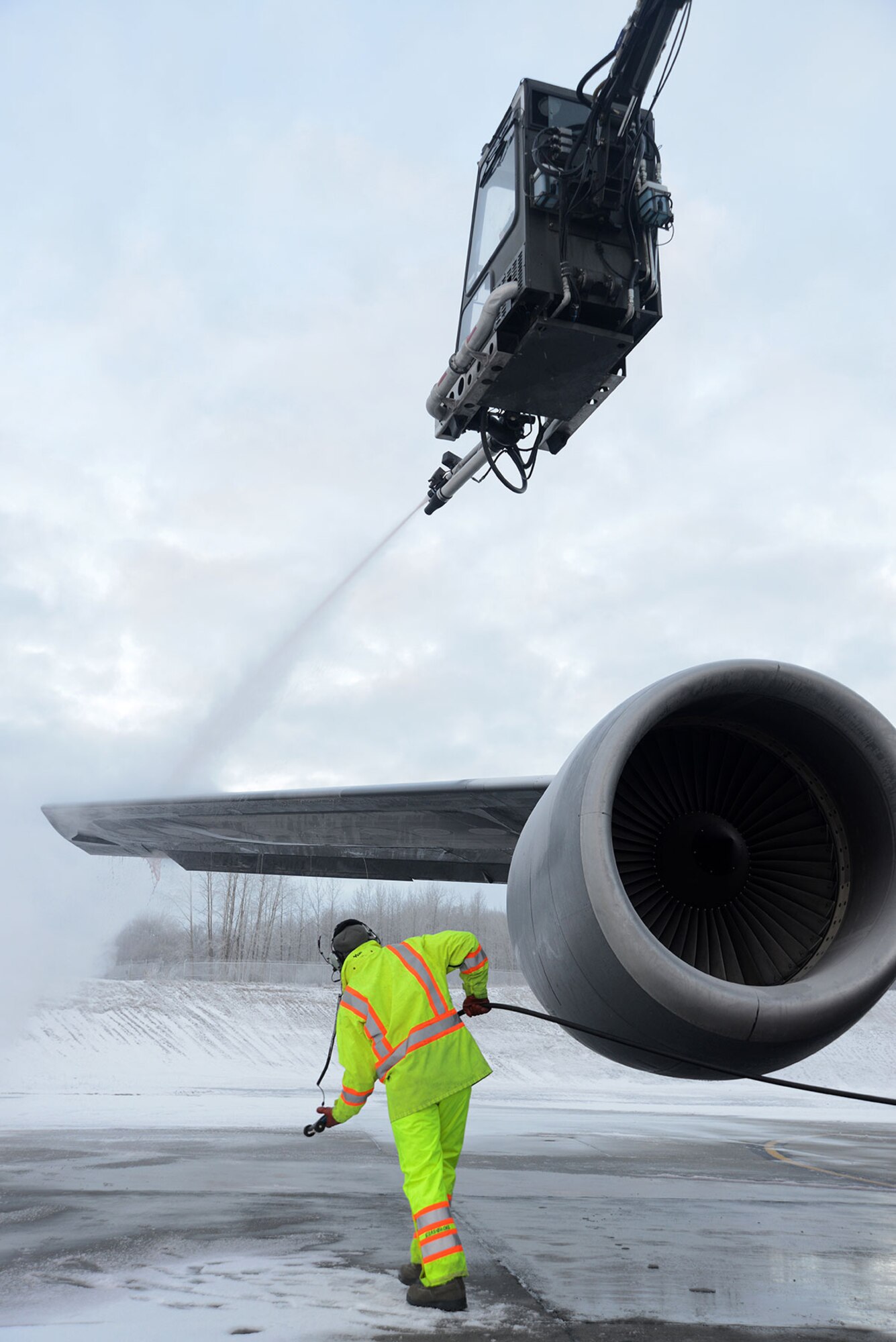 Air Force Staff Sgt. Tyler Derr (top) and Air Force Staff Sgt. Justin Fleming (bottom), 732nd Air Mobility Squadron, deice an aircraft’s wing on the flight line at Joint Base Elmendorf-Richardson, Alaska, Dec. 3, 2015. There is always a person in the truck, one in the deicer and one on the ground to make sure the aircraft is deiced all around. (U.S. Air Force photo by Airman 1st Class Christopher R. Morales)