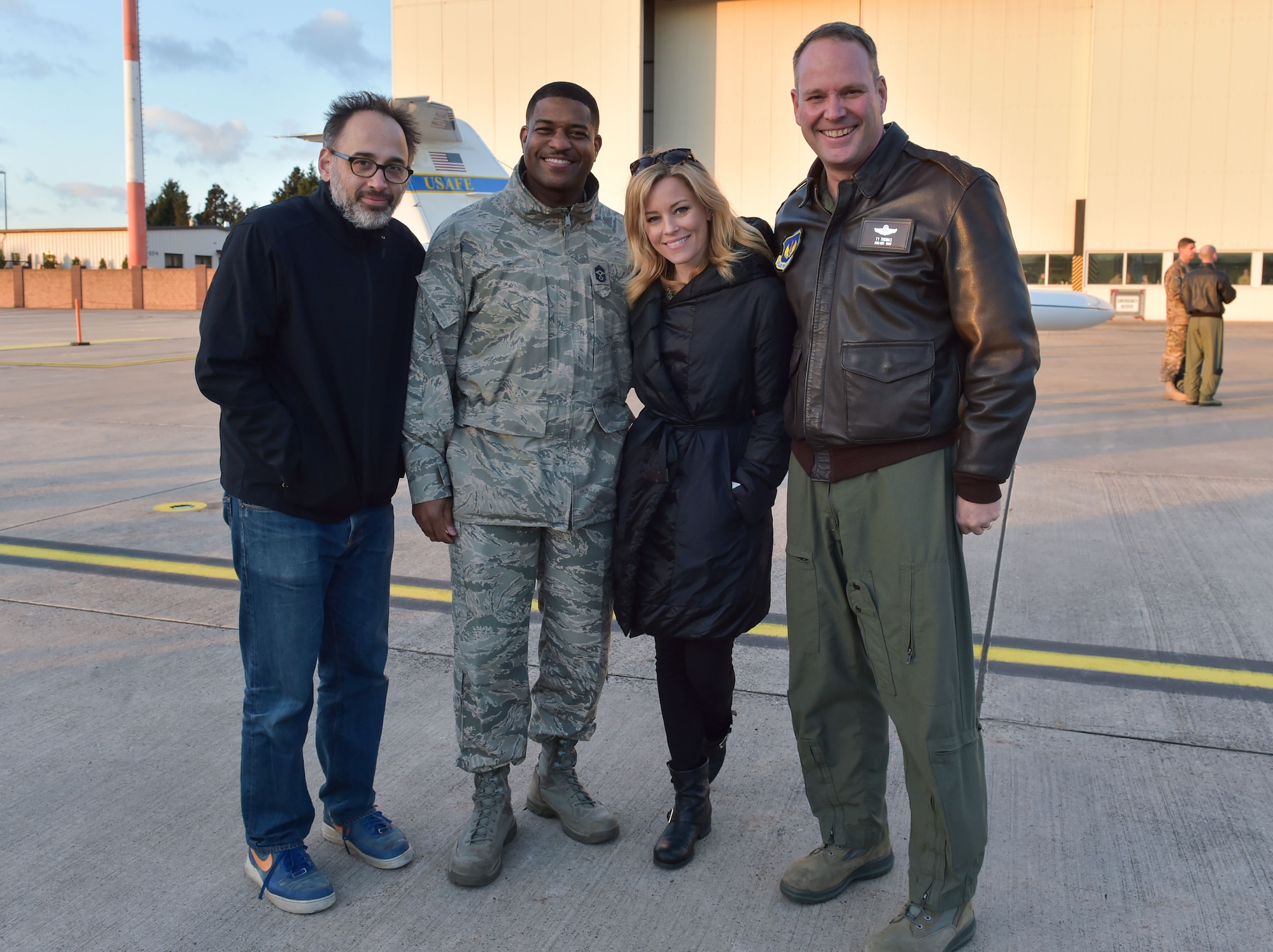 Writer and director David Wain and actress Elizabeth Banks stop for a photo with Brig. Gen. Jon. T. Thomas, 86th Airlift Wing commander, and Chief Master Sgt. Phillip Easton, 86th AW command chief, during the 2015 USO Holiday Troop Tour, Dec. 9, 2015, at Ramstein Air Base, Germany. Thomas welcomed the group of entertainers, as well as the Chairman of the Joint Chiefs of Staff during the performance opening. (U.S. Air Force photo/Staff Sgt. Leslie Keopka)