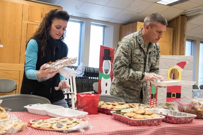 PETERSON AIR FORCE BASE, Colo. – Jennifer Dorminey and Col. Eric Dorminey, 21st Space Wing vice commander, package cookies at the Peterson Chapel on Dec. 8, 2015 for the dorm residents and those at 24-hour facilities. Hosted by the Peterson, Schriever, and Cheyenne Mountain Spouses’ Club, the annual cookie drive collected baked desserts to give to local troops during the holiday season. (U.S. Air Force photo by Senior Airman Tiffany DeNault)