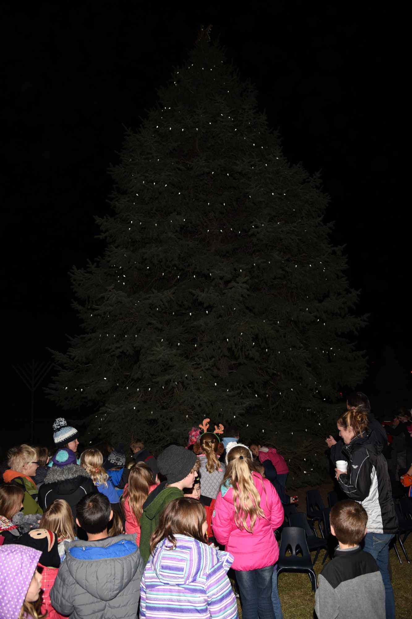PETERSON AIR FORCE BASE, Colo. – Peterson families surround the holiday tree during the tree lighting ceremony Dec. 4, 2015. Santa Claus and the Grinch visited children, while families participated in several events following the ceremony. (U.S. Air Force photo by Robb Lingley)