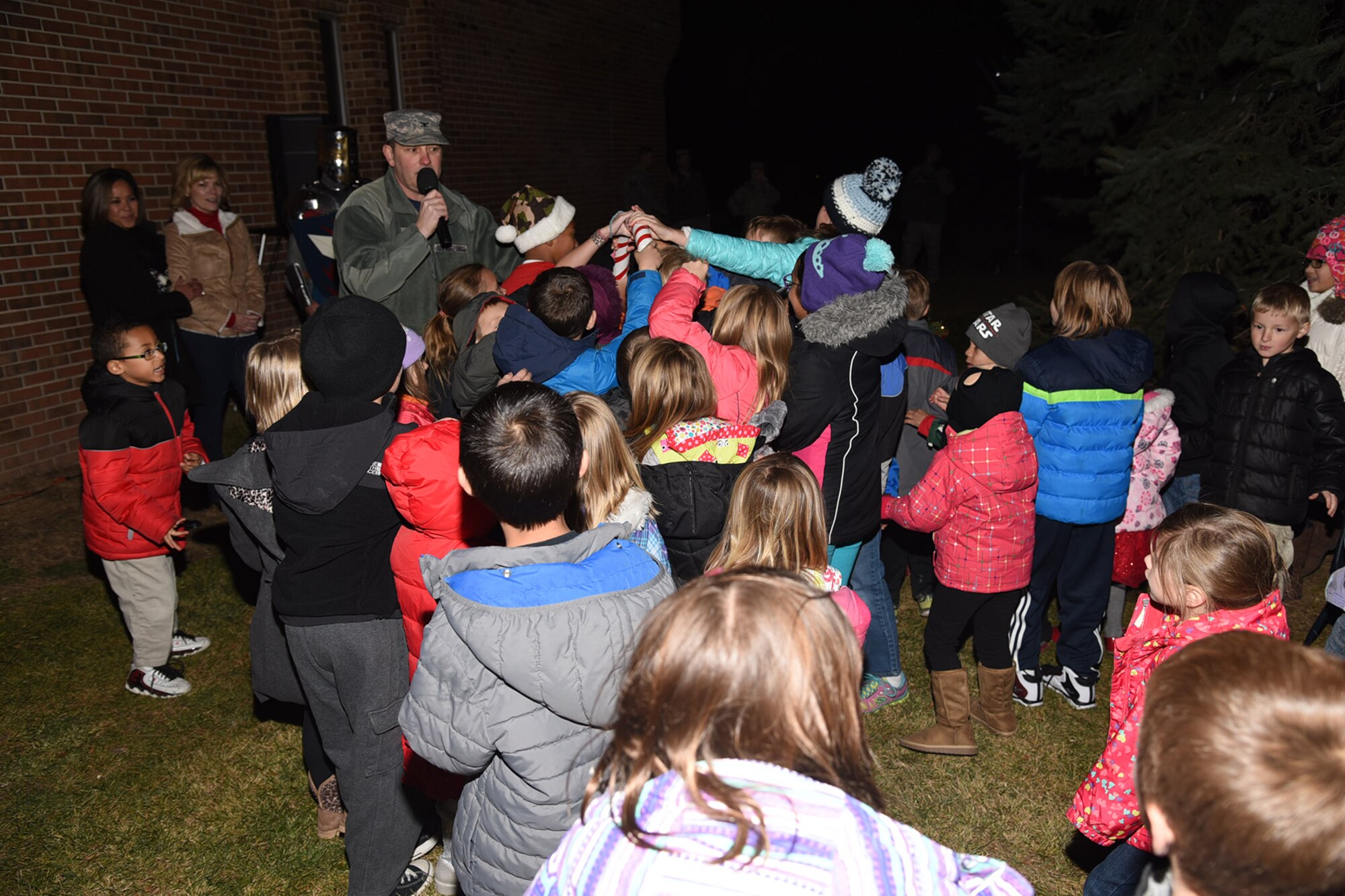 PETERSON AIR FORCE BASE, Colo. – With the help of Peterson youth, Col. Doug Schiess, 21st Space Wing commander, flips the switch that will light up the tree during the Holiday Tree Lighting ceremony Dec. 4, 2015. The Peterson Chapel sponsored the ceremony and hosted the Deployed Families Dinner following the tree lighting. (U.S. Air Force photo by Robb Lingley)