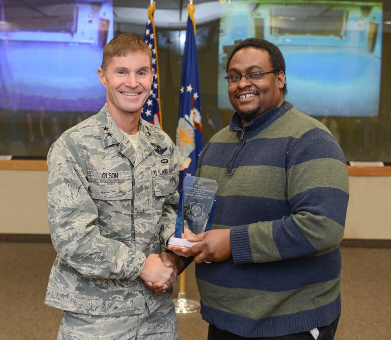 Maj. Gen. Craig Olson, C3I and Networks program executive officer, presents the 2015 Outstanding Air Force Life Cycle Management Center Program Management Trainee Award to Curtis Baldwin, C3I and Networks Directorate, during the LCMC Acquisition Management Award ceremony Dec. 8. The award recognizes a trainee who was has made outstanding contributions to a program, process or organization that contributed significantly to the success of the organization. (U.S. Air Force photo by Jerry Saslav)