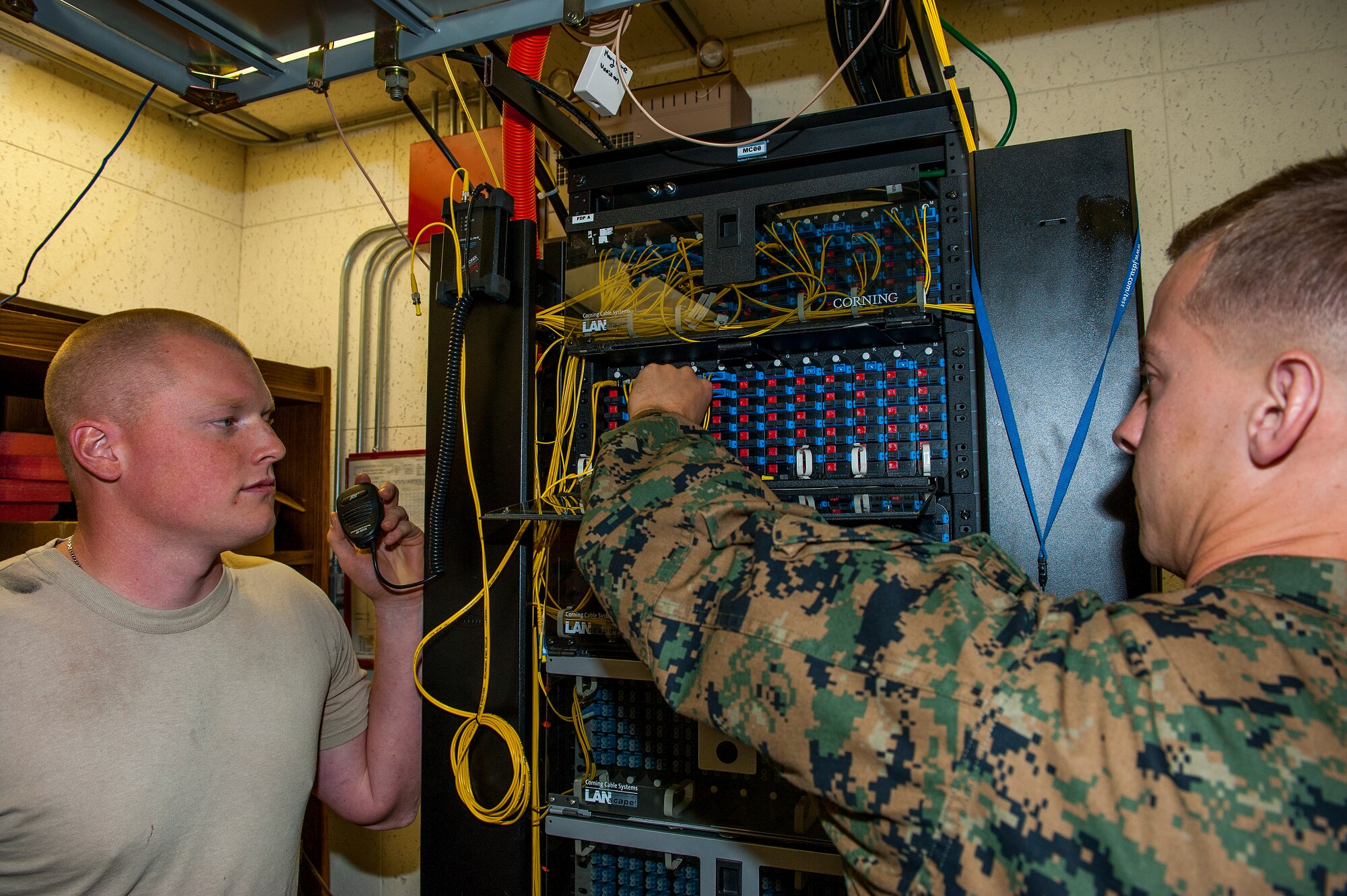 U.S. Air Force Senior Airman Jacob Schroader, 18th Communications Squadron cable and antenna systems journeyman, and U.S. Marine Corps Lance Cpl. Travis Carriger, a construction wireman with Headquarters and Service Battalion, G-6 Division, Telephone Systems Branch, work together to test the newly installed wiring Dec. 9, 2015, at Kadena Air Base, Japan. Lance Cpl. Carriger participated in an exchange program where two Airmen from Kadena’s cable and antenna shop swapped work places with two Marines from Camp Foster’s shop as a way to better integrate joint operations and knowledge. (U.S. Air Force photo by Airman 1st Class Corey M. Pettis)