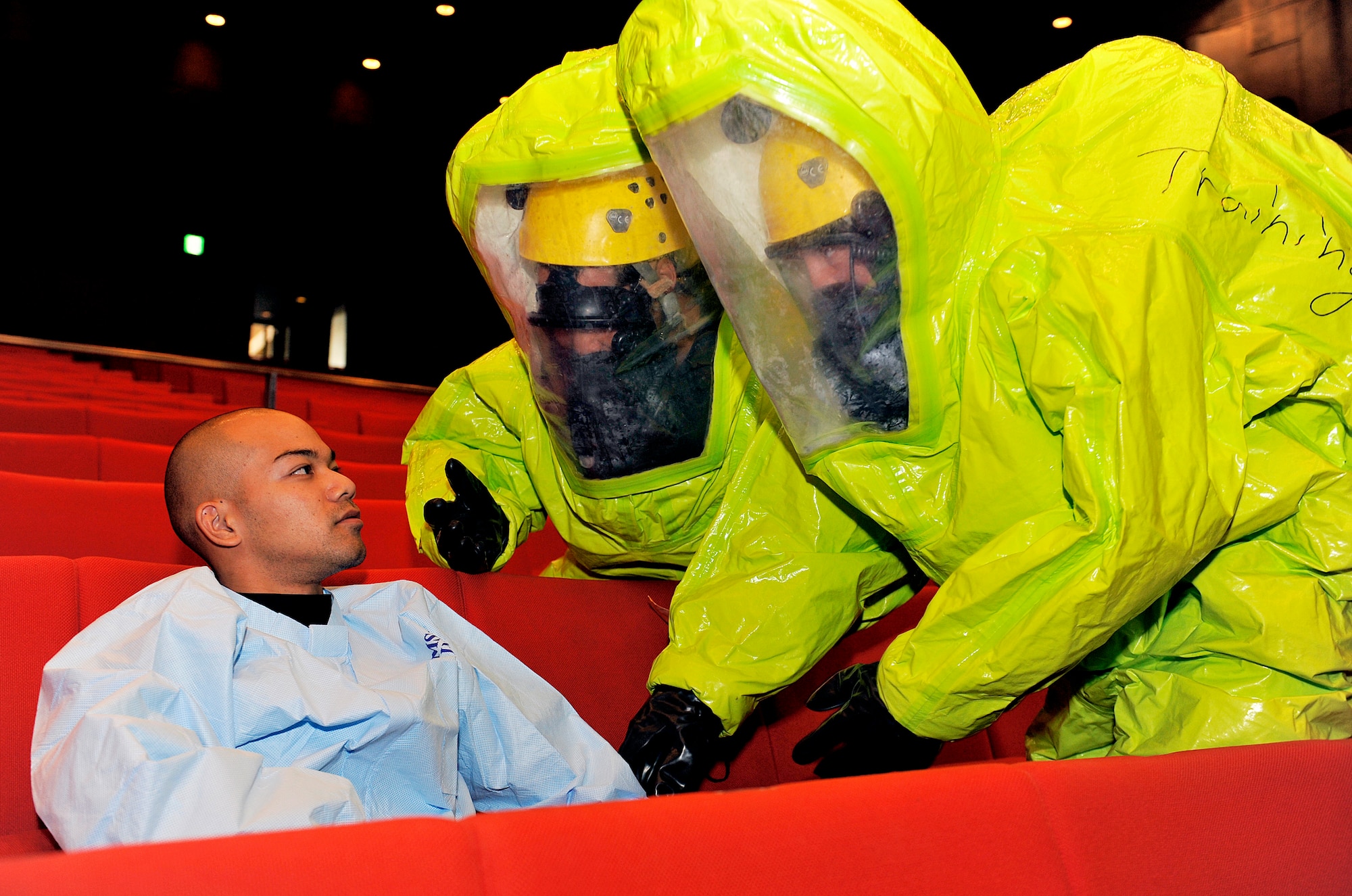 Moritaka Shiroma, 18th Civil Engineer Squadron firefighter (center), and U.S. Air Force Senior Airman Emily Beckerjeck, 18th CES driver operator (right), examine a simulated hazardous materials victim during a bilateral hazardous materials training exercise, Dec. 8, 2015, at the Okinawa City Civic Center, Japan. The purpose of this bilateral training exercise was to improve the interoperability and communication between the Okinawa City Fire Department and Kadena Air Base Fire Department, increasing the readiness and effectiveness of both agencies. (U.S. Air Force photo by Naoto Anazawa)