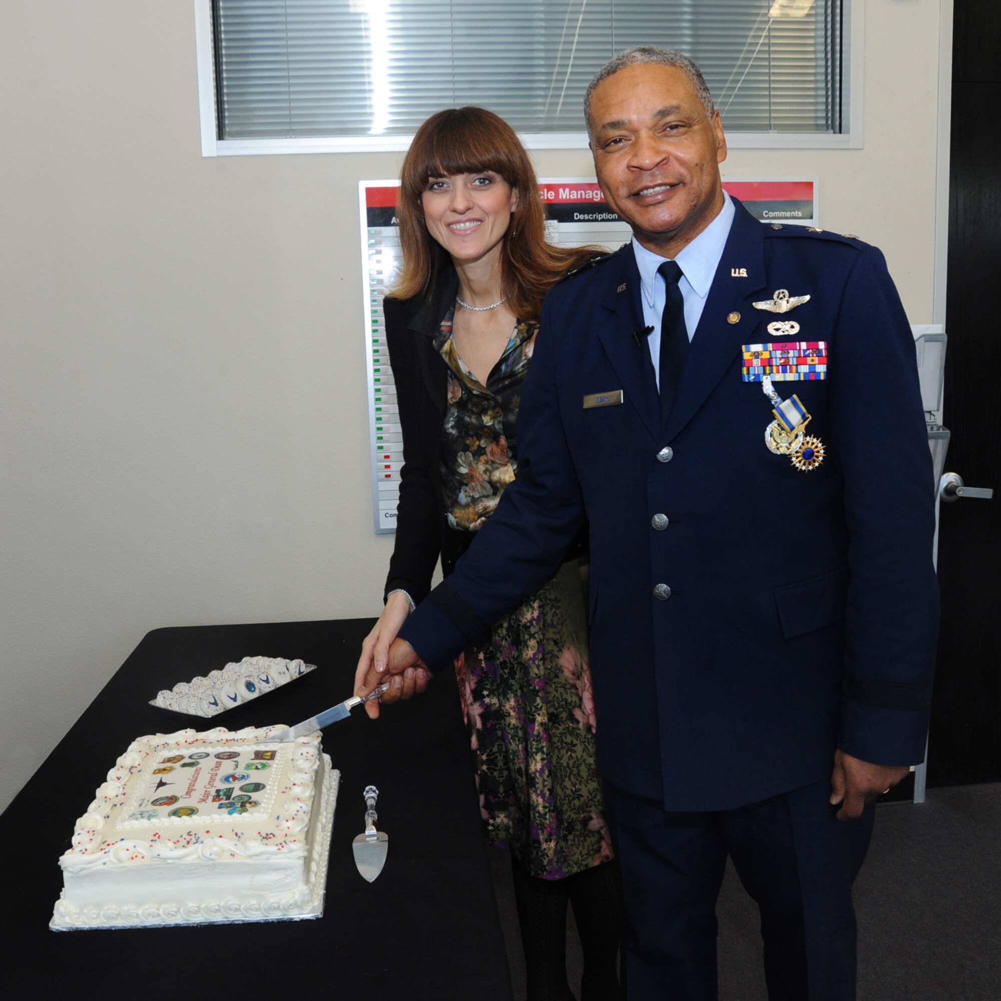 U.S. Air Force Maj. Gen. Garry Dean, The Special Assistant to the Chief, National Guard Bureau, along with his wife Elena, pause for a photograph prior to cutting a ceremonial cake following his formal retirement from the National Guard, Dec. 6, 2015, Portland Air National Guard Base, Ore. (U.S. Air National Guard photo by Tech. Sgt. John Hughel, 142nd Fighter Wing Public Affairs)