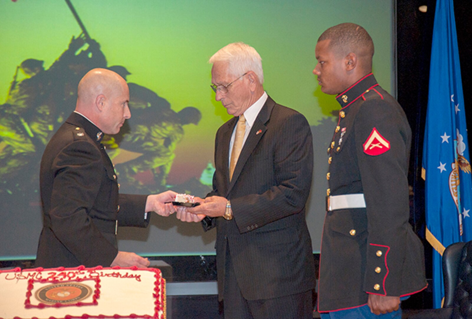 Lt. Col. Sean Murray, DLA Land and Maritime, hands a piece of cake to former Whitehall Mayor John Wolfe. Wolfe was the oldest Marine in attendance at the Marine Corps’ 240th Birthday Celebration inside the Building 20 auditorium on Defense Supply Center Columbus Nov. 10, and in tradition, received one of the first pieces of cake during the ceremony.