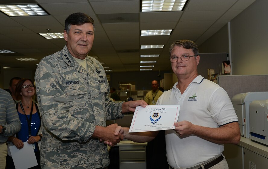 Lt. Gen. Brad Heithold, commander of Air Force Special Operations Command, presents a Cutting Edge award to Michael Williams, AFSOC manpower, personnel and services directorate, at Hurlburt Field, Fla., Dec. 9, 2015. (U.S. Air Force photo/Staff Sgt. Melanie Holochwost)