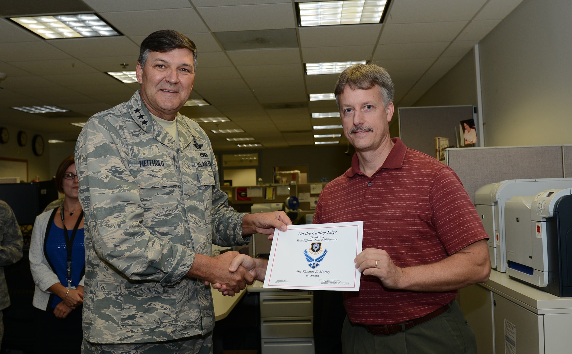 Lt. Gen. Brad Heithold, commander of Air Force Special Operations Command, presents a Cutting Edge award to Thomas Morley, AFSOC manpower, personnel and services directorate, at Hurlburt Field, Fla., Dec. 9, 2015. (U.S. Air Force photo/Staff Sgt. Melanie Holochwost)