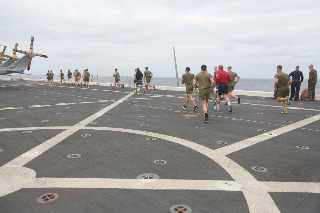 PACIFIC OCEAN (Dec. 7, 2015) U.S. Marines with 1st Light Armored Reconnaissance Detachment, Battalion Landing Team 3rd Battalion, 1st Marine Regiment, 15th Marine Expeditionary Unit work out for family members on the flight deck aboard the USS Anchorage (LPD 23). The 15th MEU is coming to the end of deployment and hosting a Tiger Cruise for family members to showcase life aboard the Anchorage. (U.S. Marine Corps photo by Sgt. Steve H. Lopez/Released)